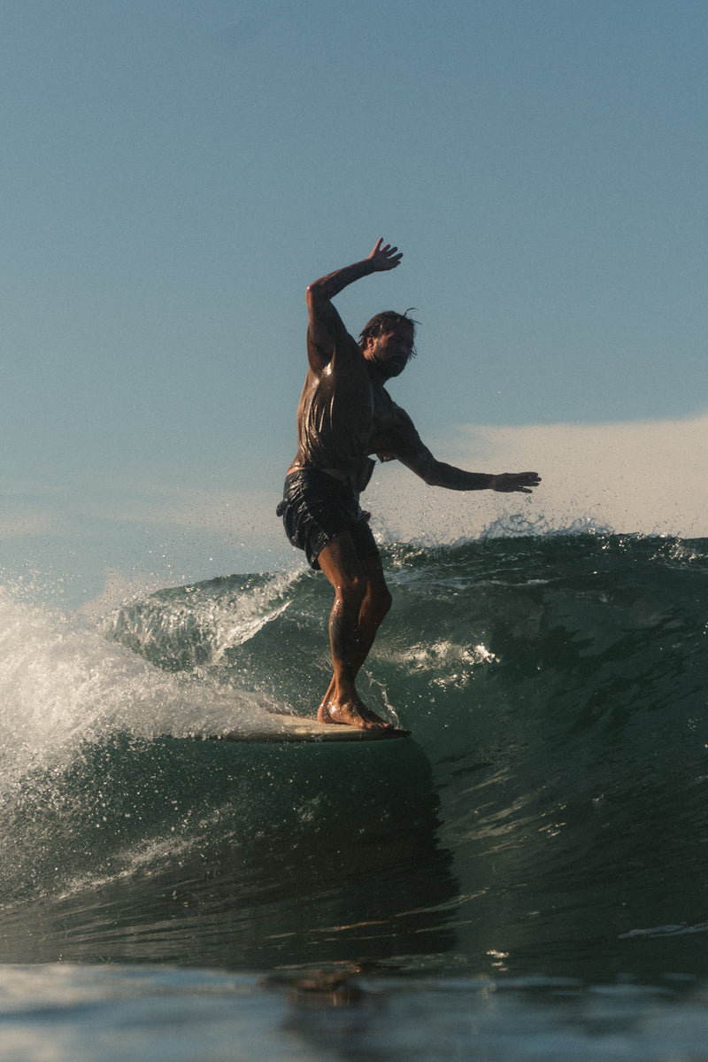 surfer doing hang five in bali, lonbgoards for sale in bali